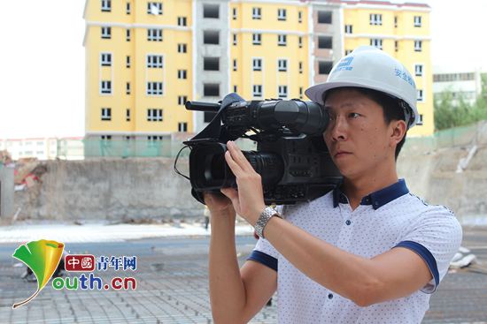 2014年7月，祁兴飞在建筑施工一线进行采访。m88登录入口官网团委 供图